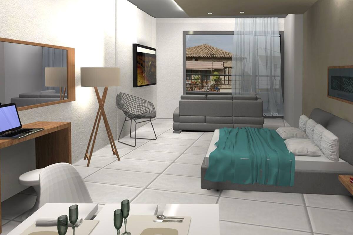 A modern hotel room with a desk, laptop, chair, sofa, and a balcony with a view.