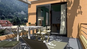 An outdoor patio with a table and chairs, a lamp, and a view of a mountain. - Derveni Luxury Apartments  (Xylokastro-Evrostina)