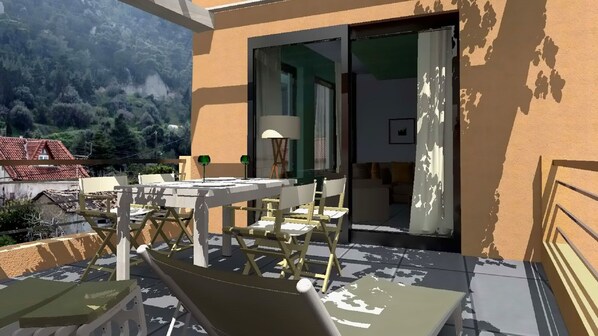 An outdoor patio with a table and chairs, a lamp, and a view of a mountain.