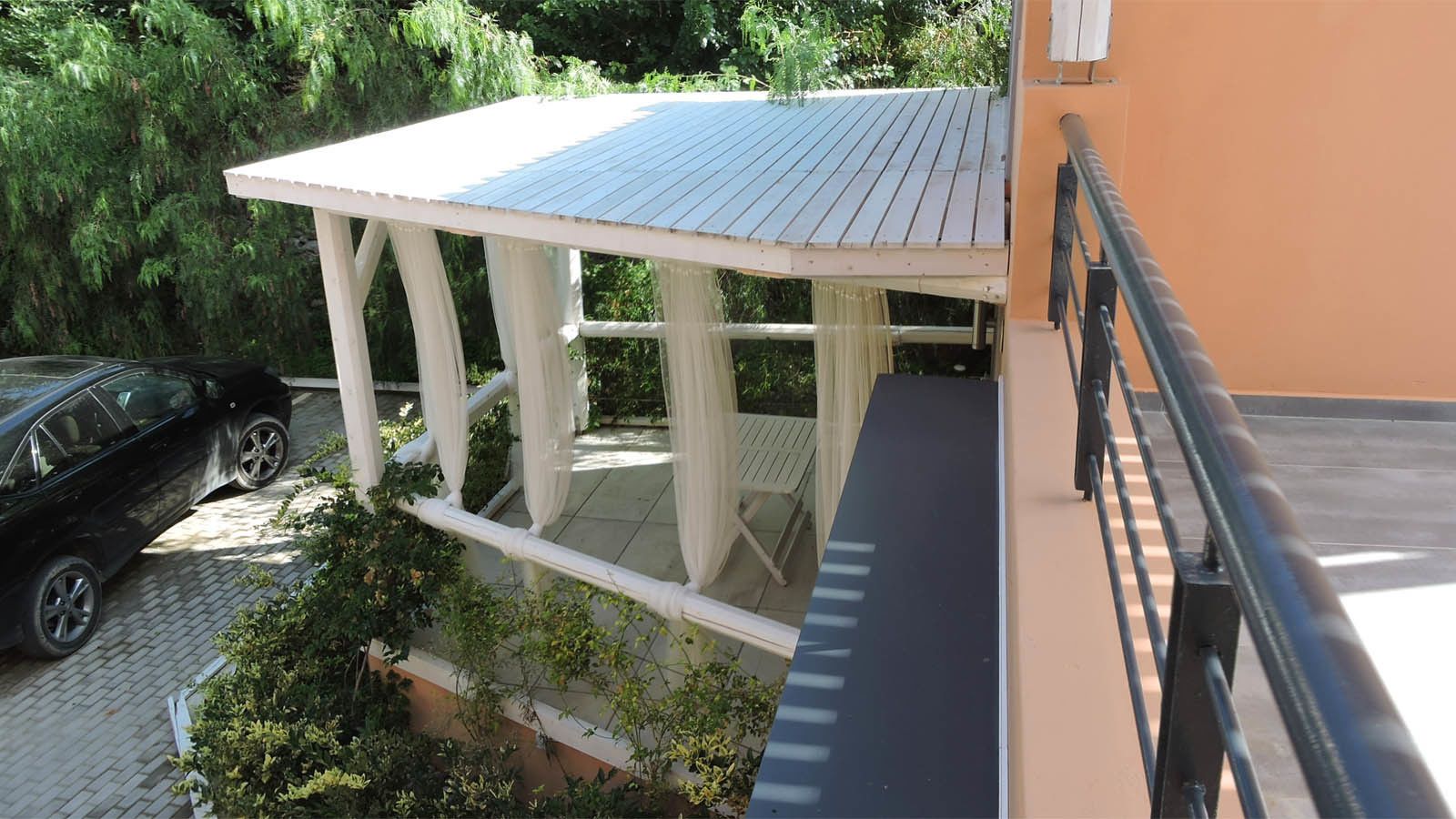 A covered outdoor area with a car parked nearby.