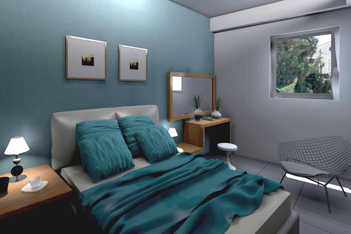 A modern bedroom with a bed, nightstands, a chair, and a window.