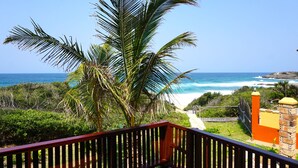 Un balcon avec vue sur une plage et l’océan.