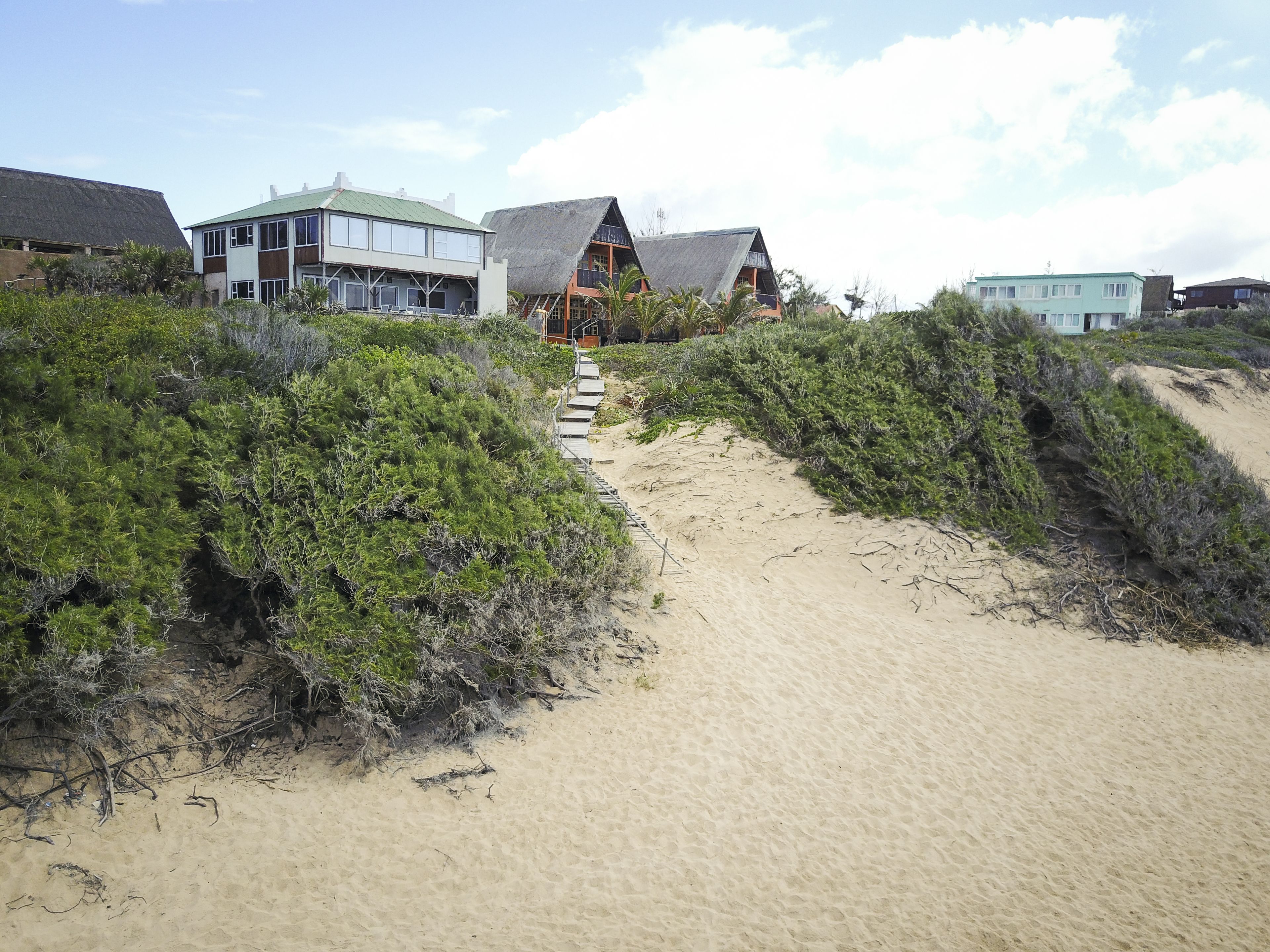 Am Strand, weißer Sandstrand, Liegestühle, Sonnenschirme