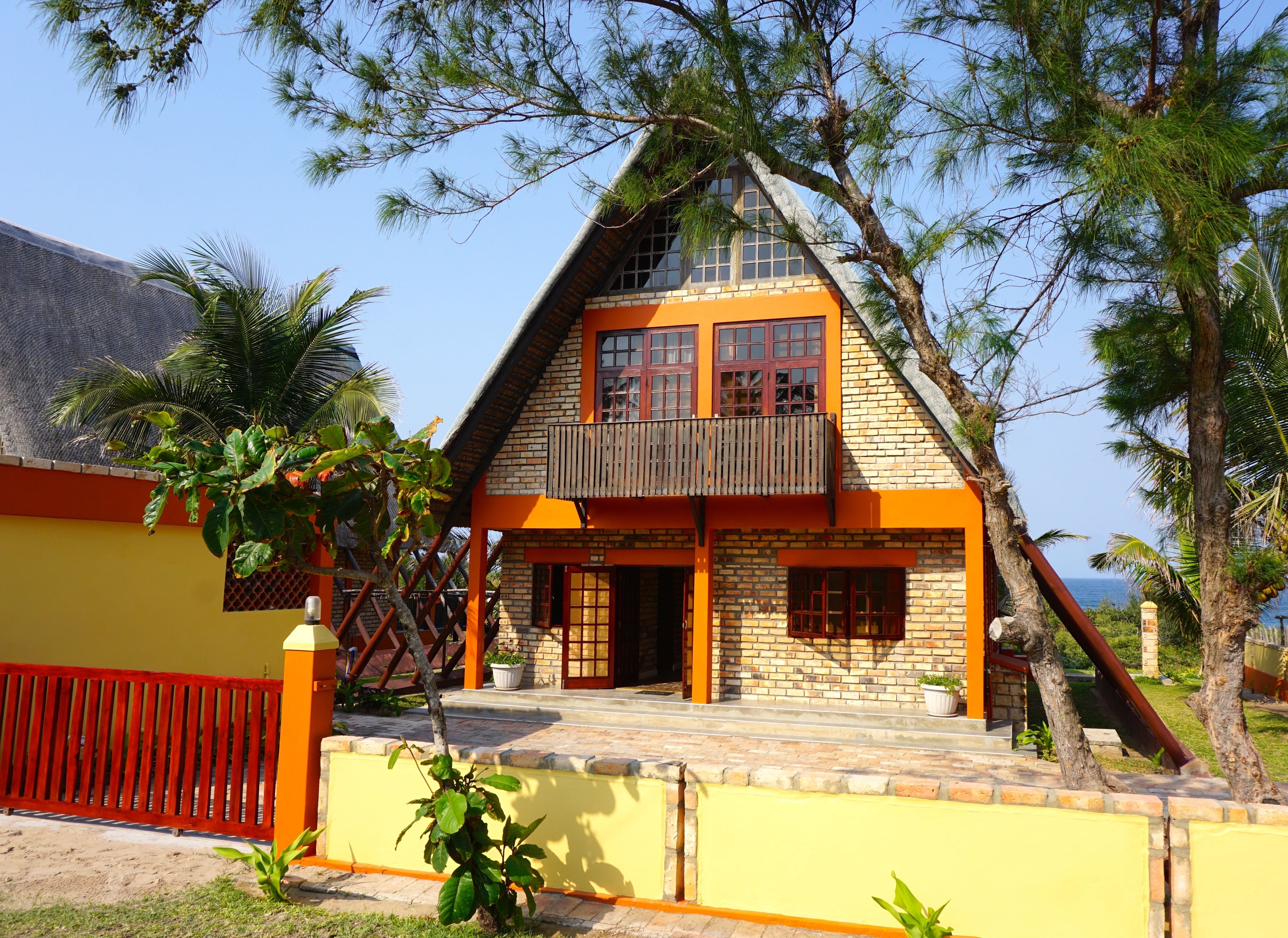 A two-story house with a sloped roof, a balcony, and a small porch.