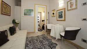 A modern living room with a white sofa, a zebra-patterned rug, and a dining area with a small table and chairs. - Lori's Inn (Mondovi)