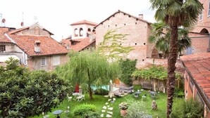 A courtyard with stone pathways, outdoor seating, and lush greenery. - Lori's Inn (Mondovi)