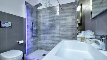 Une salle de bain moderne avec une douche à parois de verre, un lavabo blanc et des toilettes.