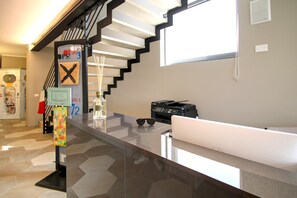 Eine moderne Küche mit Einbauherd, Kühlschrank und einer Arbeitsplatte, auf der eine Kaffeemaschine und eine Vase stehen.