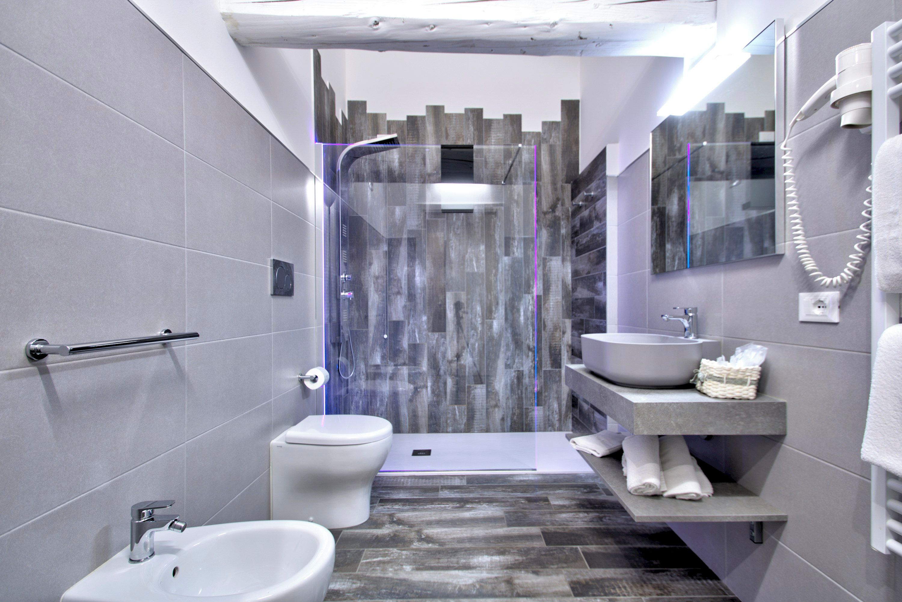 Ein modernes Badezimmer mit Dusche, Toilette, Bidet und Waschbecken.