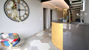 Een modern interieur met een grote wandklok, een bijzondere zithoek en een trap.
