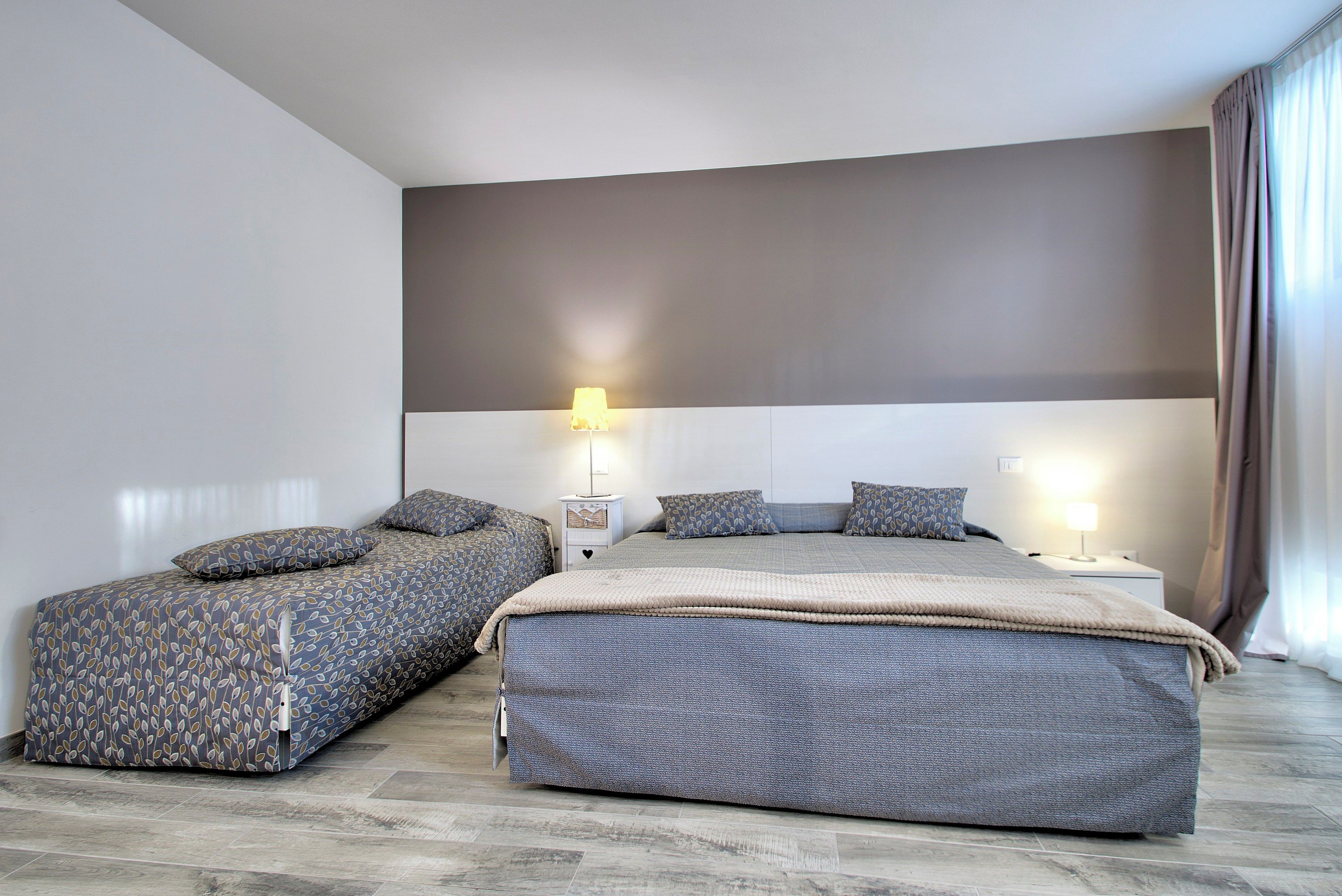 Un dormitorio moderno con una cama grande, dos mesitas de noche y una mesilla.