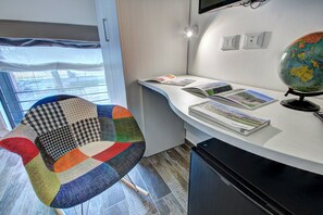 Una habitación moderna con un escritorio curvo, un globo y una silla colorida.