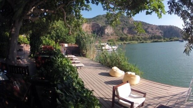 A wooden deck with outdoor seating and a view of a lake.