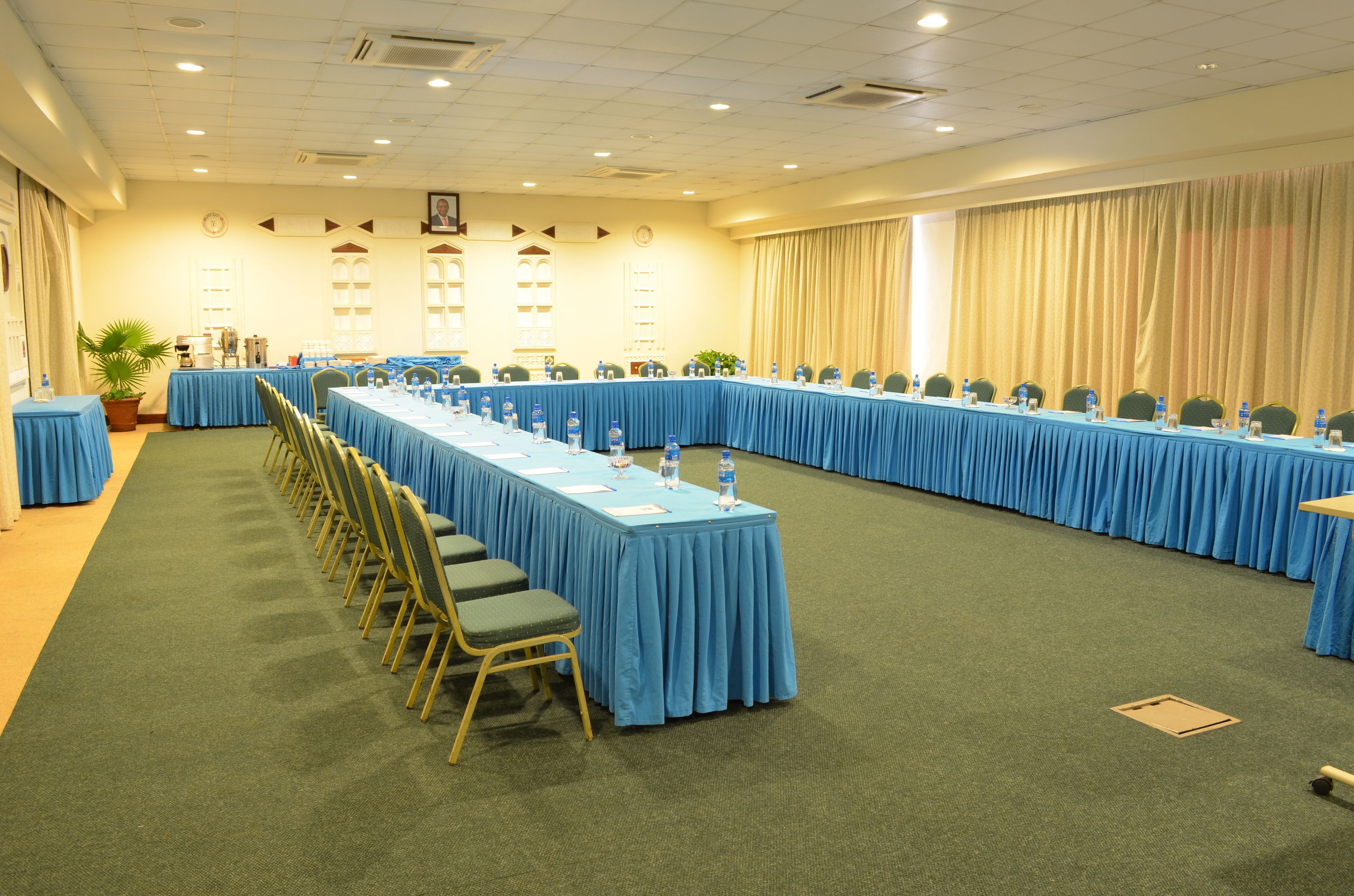 A conference room with long tables and chairs, equipped with water bottles and nameplates.