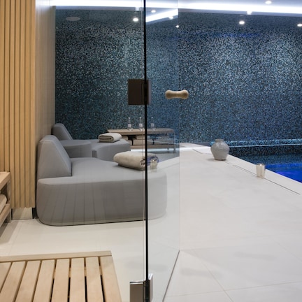 A modern spa area with a seating area, a small table, and a decorative wall.