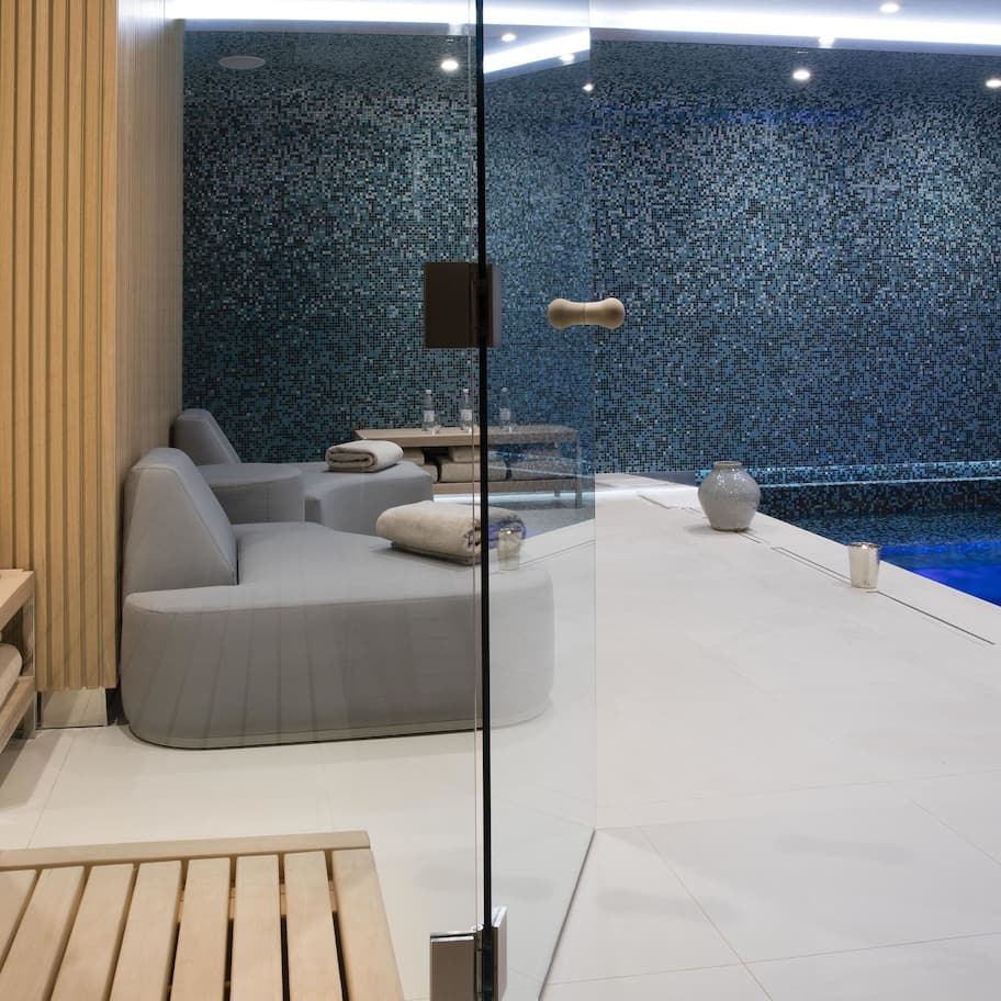 A modern spa area with a seating area, a small table, and a decorative wall.