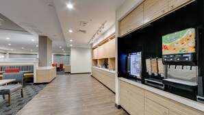 A modern hotel lobby with a seating area, a refreshment station, and a counter. - TownePlace Suites by Marriott Kansas City Liberty (Liberty)