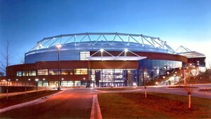 A modern stadium with a large central dome and multiple entry points.