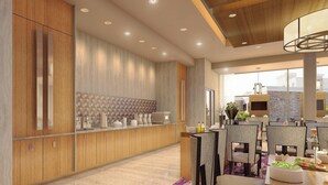 A modern kitchen with wooden cabinets, a tiled backsplash, and a dining area with wicker chairs and a table.