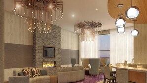 A modern living room with a stone accent wall, a fireplace, a curved sofa, and a bar area with stools.