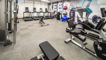 A gym with treadmills, weight machines, and exercise balls.