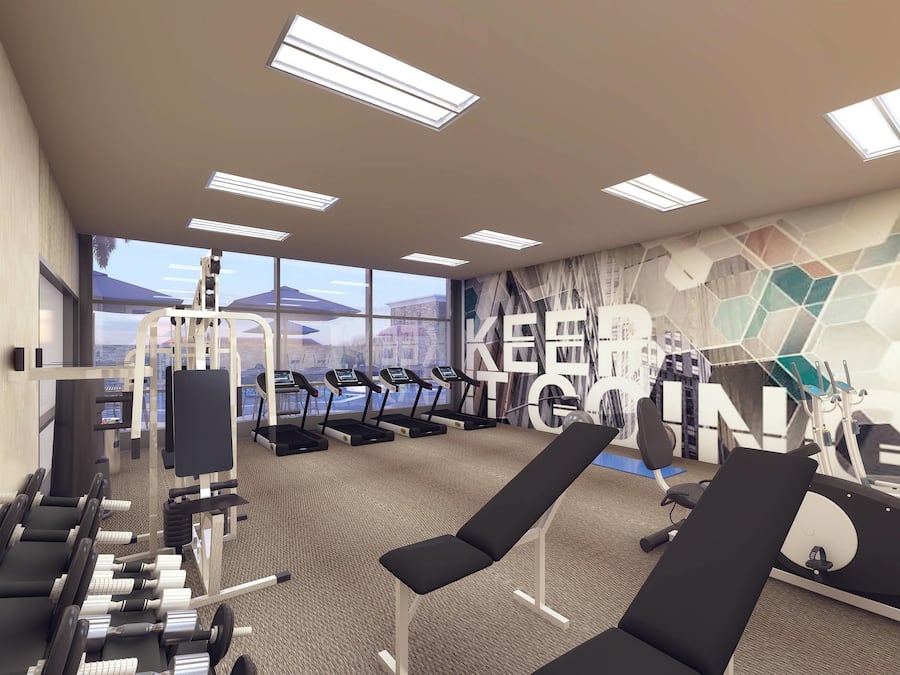 A modern gym with exercise equipment, large windows, and a geometric wall mural.