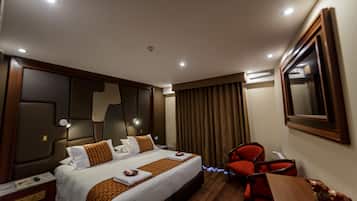 Una habitación de hotel con cama, escritorio, silla y un espejo grande en la pared.