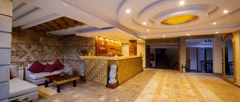A spacious lobby with a reception desk, a sofa, and a coffee table.