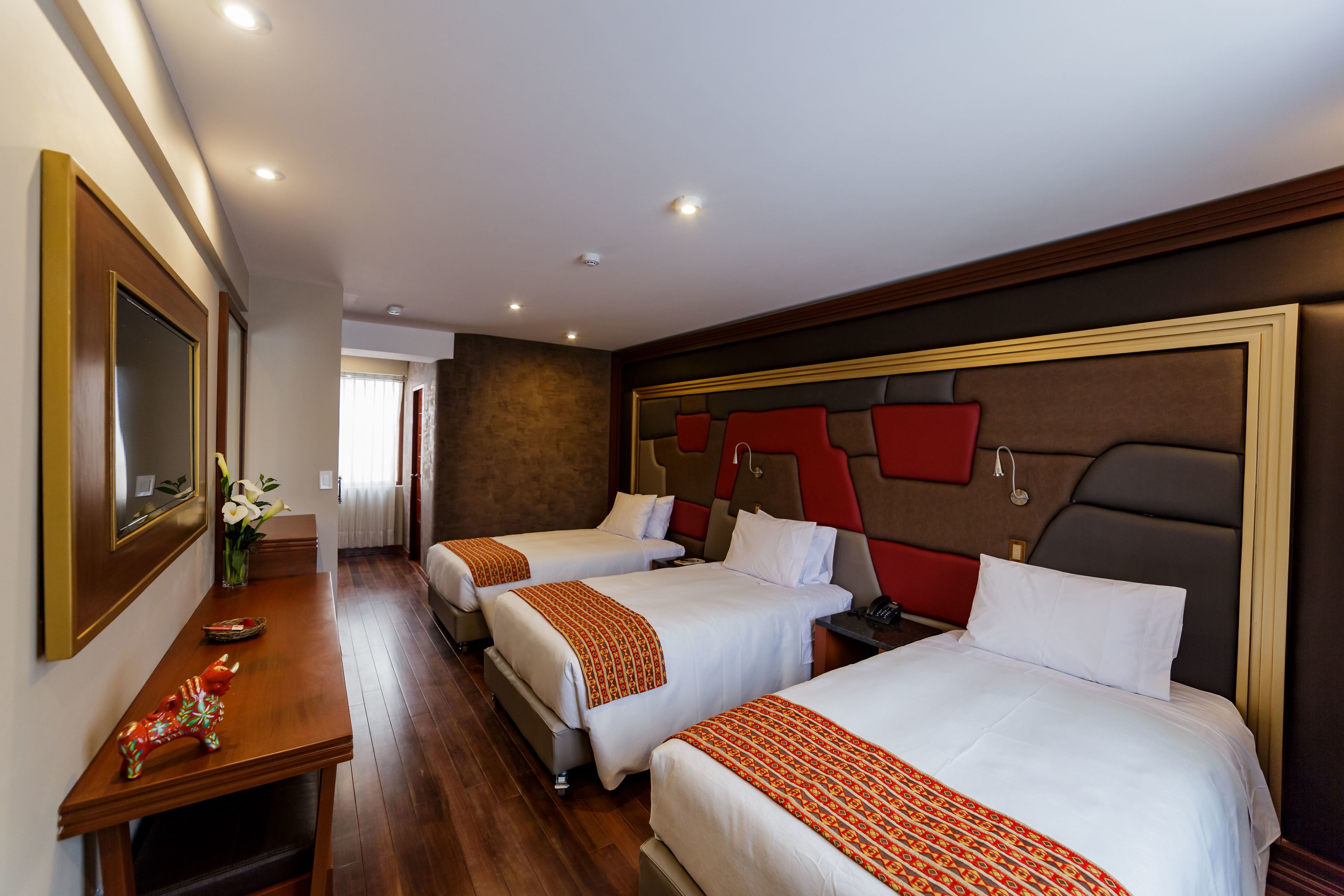 Habitación de hotel con dos camas, un escritorio y un espejo.