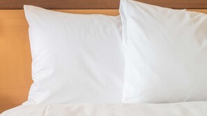 A bed with white bedding and pillows.