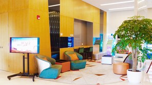 A modern lobby with seating areas, a television screen, and a potted plant. - Holiday Inn Express Suzhou Taihu Lake by IHG (Suzhou)