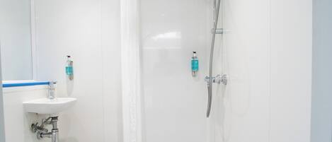 A modern bathroom with a shower, toilet, and sink.