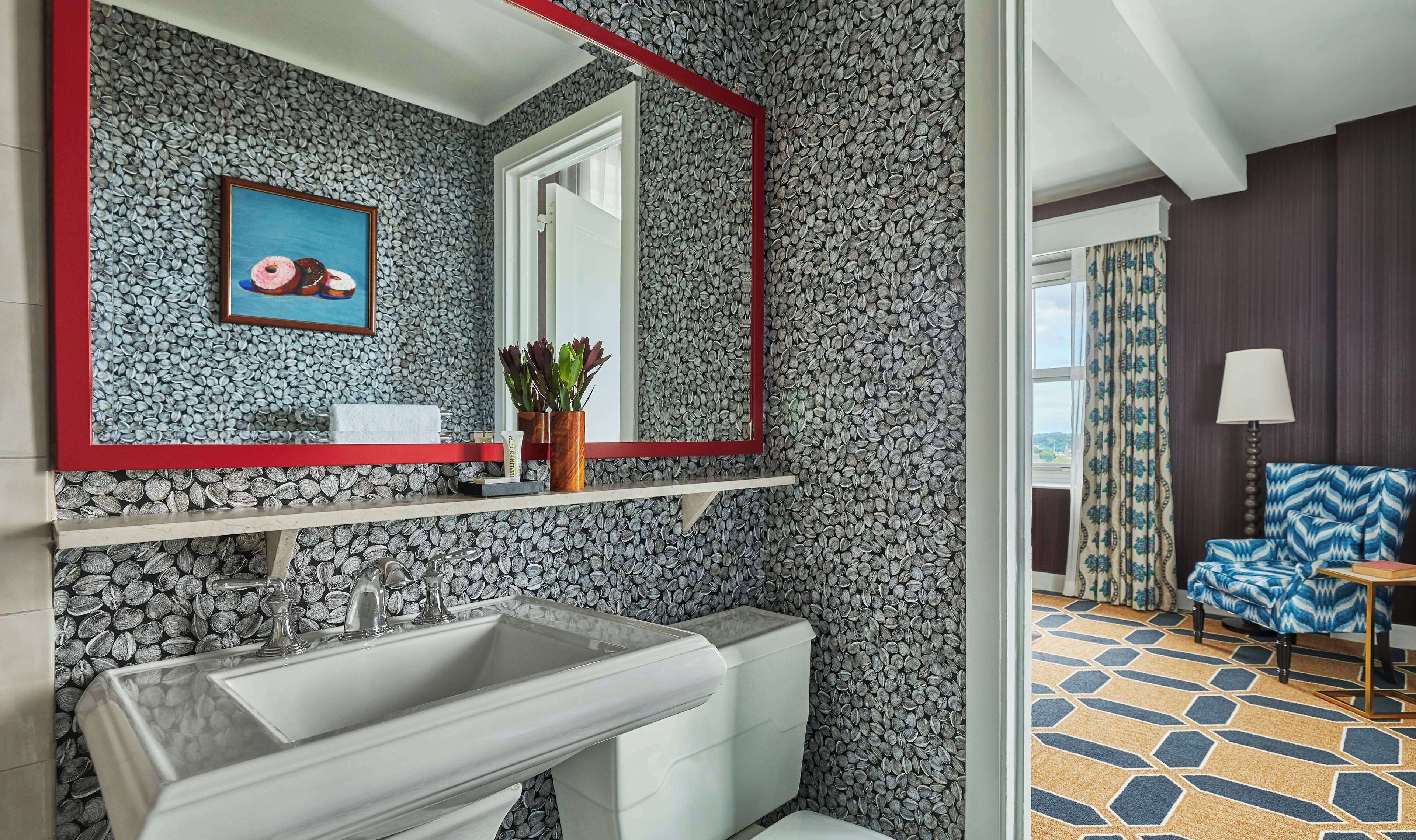 A bathroom with a sink, mirror, and a framed picture on the wall.