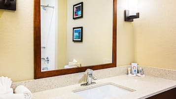 A bathroom with a sink, mirror, towel rack, and framed pictures on the wall.