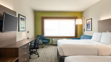 A hotel room with a bed, a desk with a chair, a television, and a window with a view.