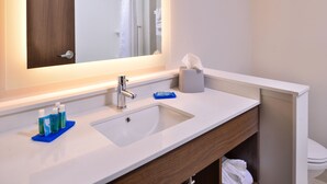 Une salle de bain avec un lavabo blanc, un miroir et un porte-serviettes.