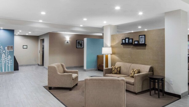 A spacious lobby with a beige sofa, armchairs, a small table, and a lamp. - MainStay Suites Big Spring North I-20 (Big Spring)