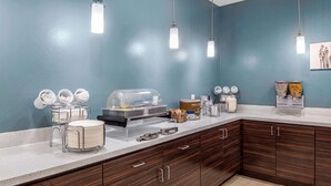 A breakfast bar with a buffet setup, including a glass display case, bowls, and a coffee station. - MainStay Suites Big Spring North I-20 (Big Spring)