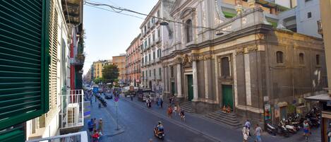 A street with historic buildings, a clear sky, and people walking.