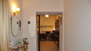 Un couloir avec un bureau, une chaise et un miroir.