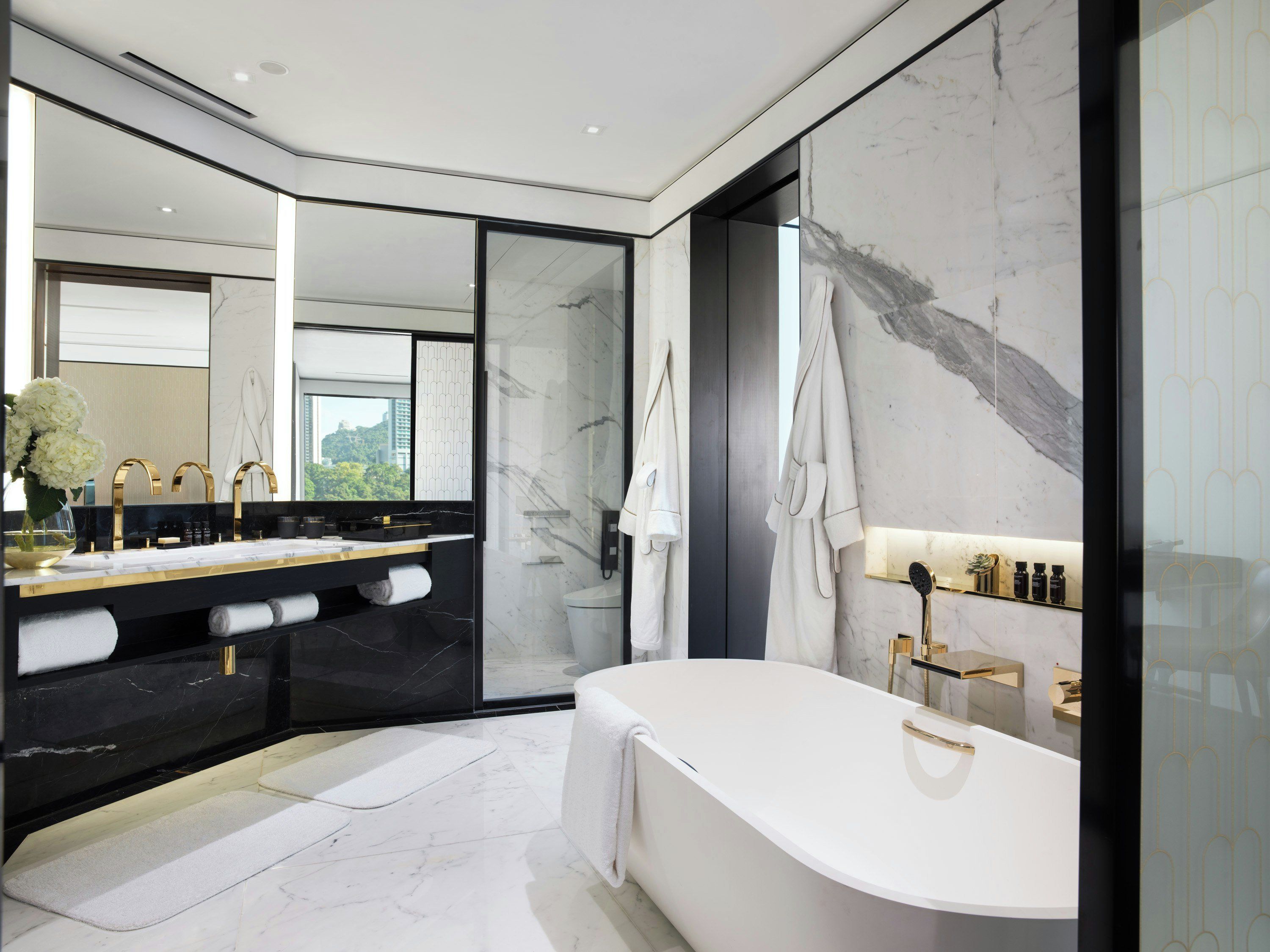 Ein modernes Badezimmer mit einer großzügigen Badewanne, einem Waschtisch inklusive Spiegel und einer Duschkabine.