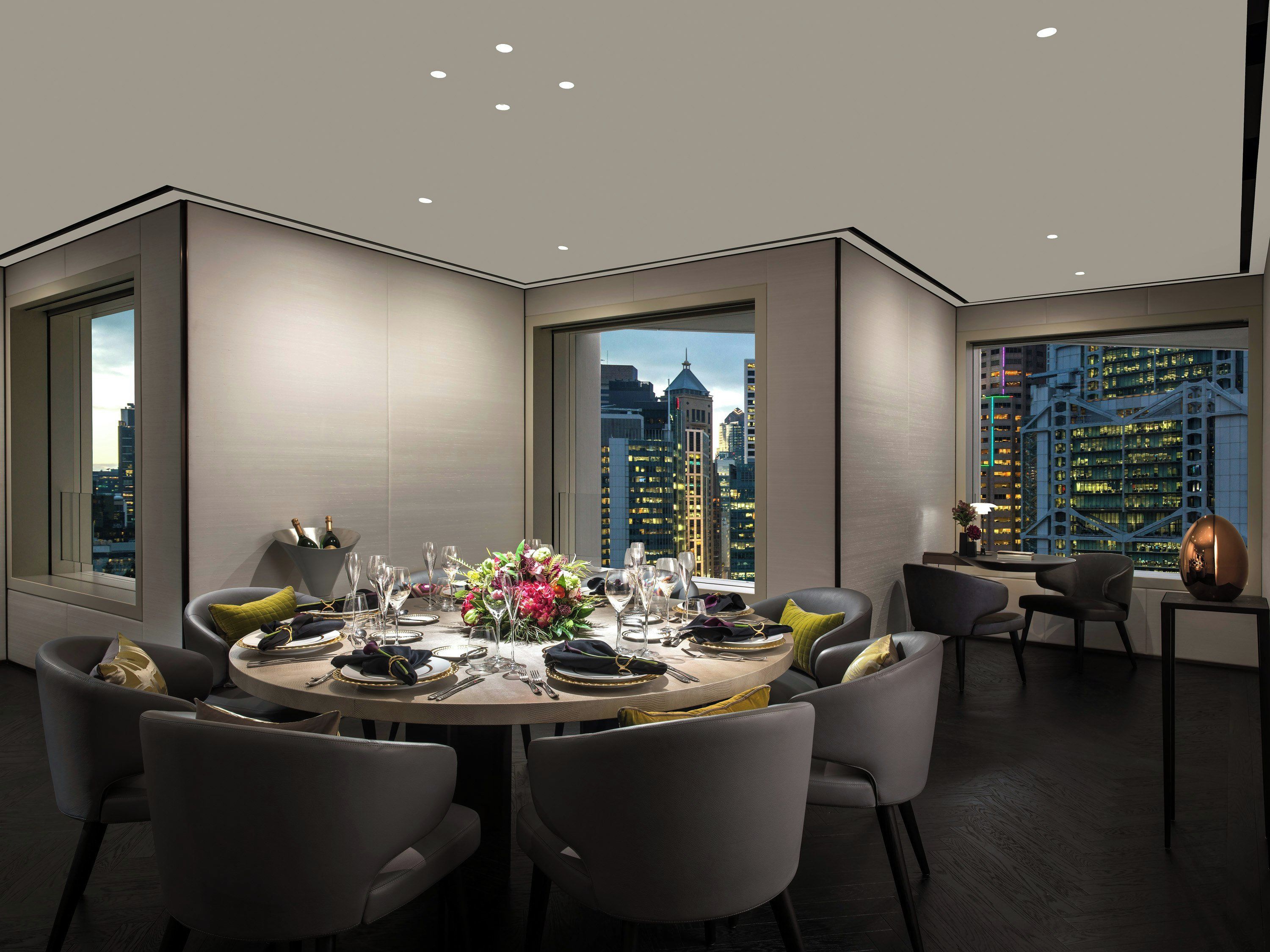 A modern dining room with a city view, a round table set for six, and a large window.