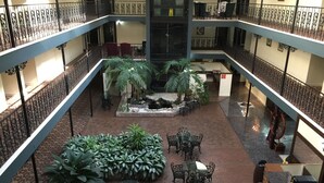 Un atrium à plusieurs niveaux, doté d’un jardin central, d’un espace extérieur aménagé pour s’asseoir et d’un escalier.