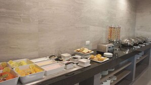 Un buffet proposant une variété de plats et d'ustensiles.
