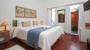 Minibar, escritorio, cortinas blackout y tabla de planchar con plancha 