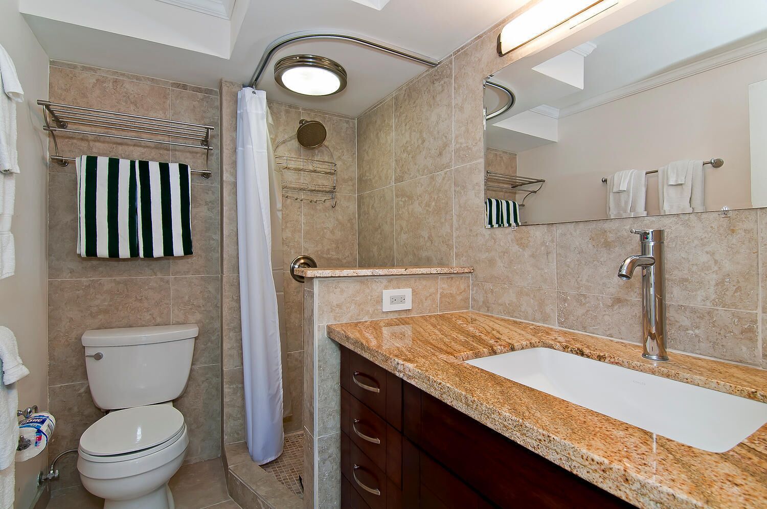 A bathroom with a toilet, a sink, a shower, and a towel rack.