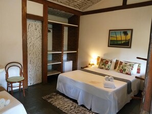 Una habitación de hotel con cama, una silla, un escritorio y un armario.