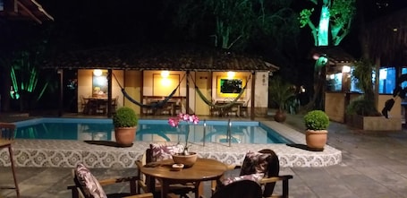Una piscina al aire libre, sillones reclinables de piscina