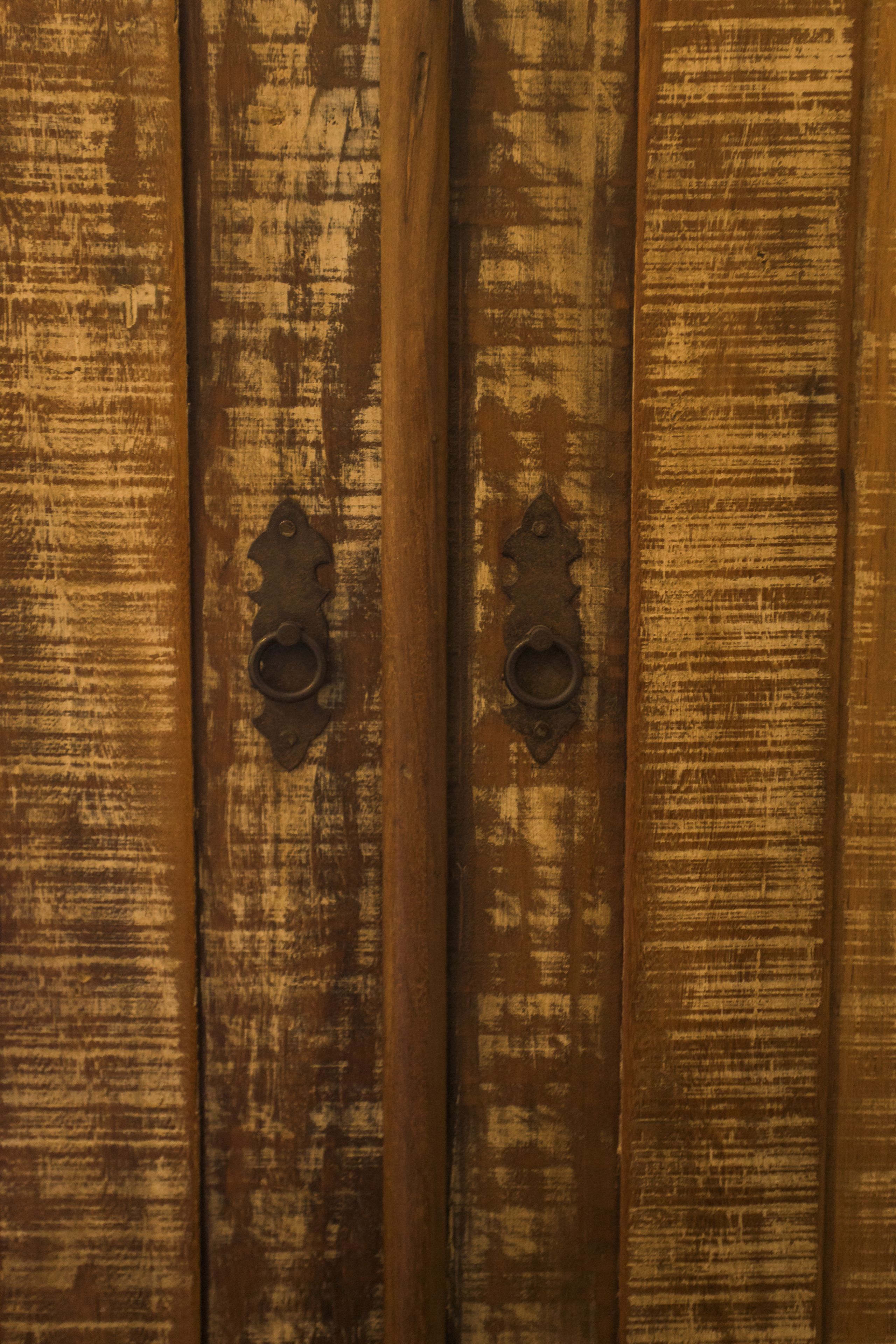A wooden door with two metal handles.