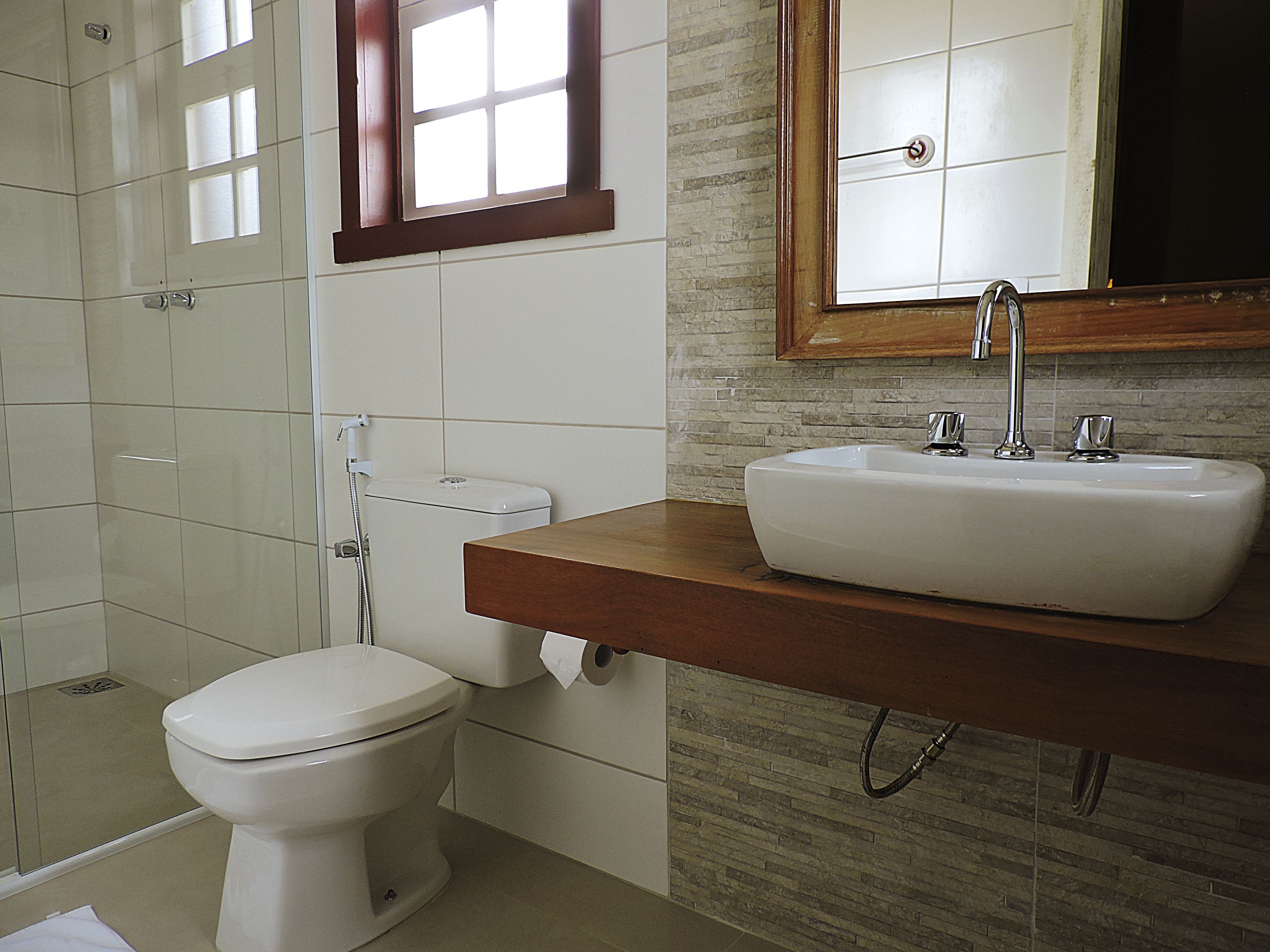 Un baño con inodoro, ducha y lavabo con espejo.